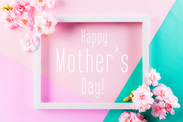Happy Mother's Day, Women's Day or Valentine's Day greeting concept. Pastel Pink and Green Colours Background with picture frame and blossom flowers flat lay patterns.
