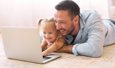 Father teaching his daughter how to use pc