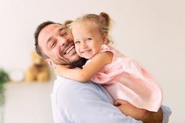 Caucasian father holding his cute loving daughter - obrazy, fototapety, plakaty