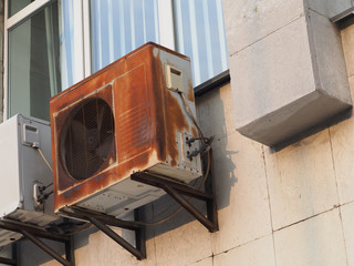 Fototapeta na wymiar old rusty outdoor air conditioner unit on the wall of the house 