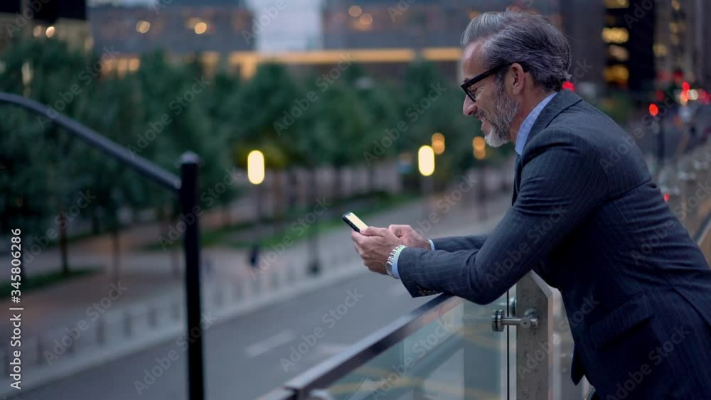 Poster successful businessman typing text message and checking balance on online banking account via mobile