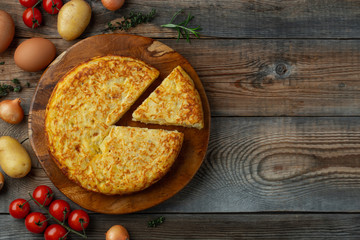 Spanish omelette with potatoes and onion, typical Spanish cuisine. Tortilla espanola. Rustic dark...