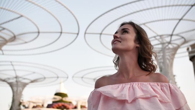 Girl on the background futuristic metal flowers in Dubai Park.