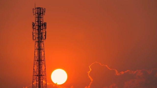 Big red sunset timelapse and tower telecommunication on golden sky background 
