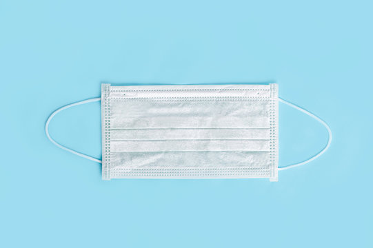 Medical surgical  mask on blue background. top view
