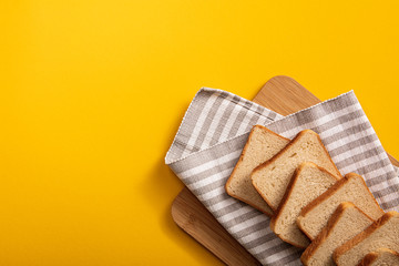 The bread on the table top view. Bright background with square of bread, a wooden Board.