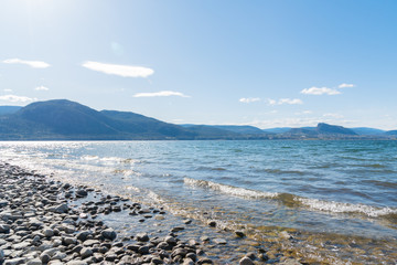 Okanagan Lake scenic view with blue sky and mountains on sunny afternoon