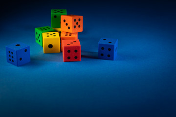 Bunte Spiel Würfel auf einem eleganten dezenten blauen Hintergrund Design in leuchtenden bunten...