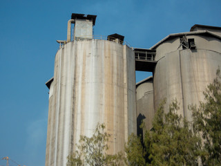 Cylindrical silos high in the sky behind the sky.
