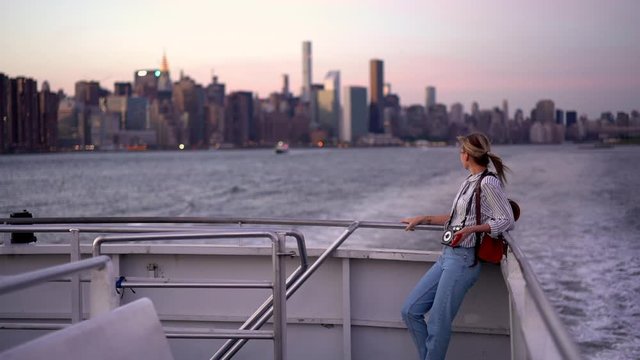 Young female traveller with camera equipment for photographing hobby enjoying water transportation for discover New York city, youth lifestyle and leisure for recreating
