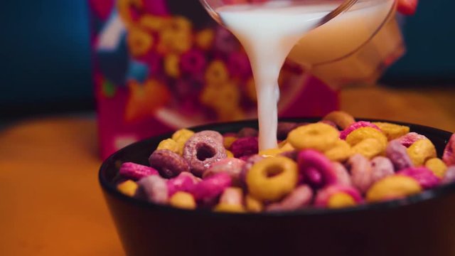 Colorful Cereals in a bowl with milk filled in in slowmotion.