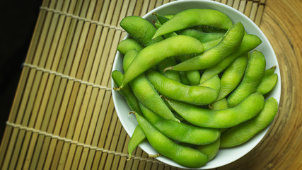 Edamame  in white bowl top view image for food content.