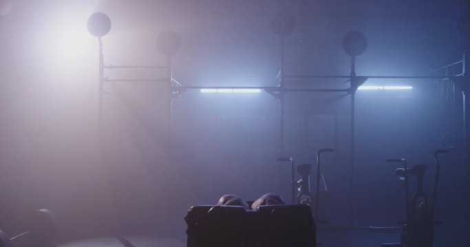 Strong girl working out in dark gym