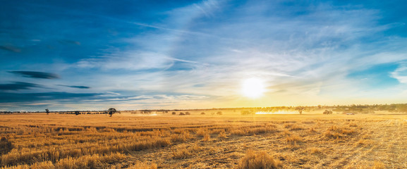 Vast panoramic view of rural farming landscape as the sun sets over the land