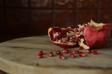 Torn Pomegranate on a wooden chopping board