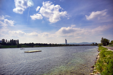 The Danube River runs through the city of Vienna, Austria on a sunny day.