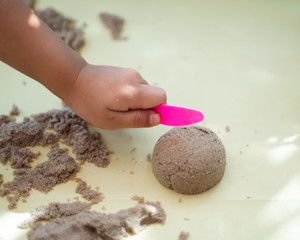Child's hand playing with kinetic sand in preschool. The development of fine motor concept. Creativity Game concept.