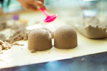 Blurry photo of kinetic sand in preschool. The development of fine motor concept. Creativity Game concept.