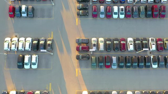 New Cars, Trucks, SUVs For Sale and glistening in the sun, Large Automobile Dealership, Springtime aerial view at sunrise.