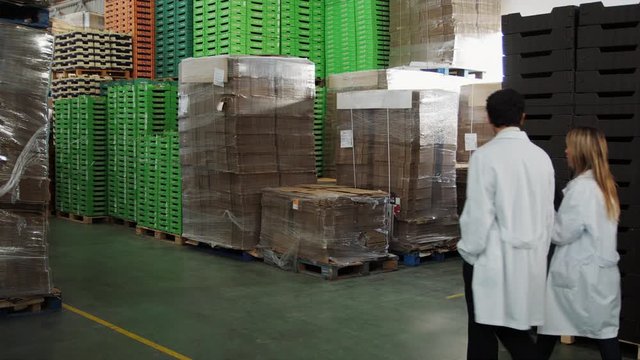 WS DS TS MS People in lab coats walking in warehouse in food processing plant