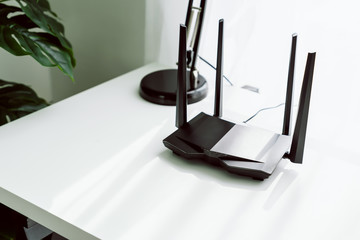 Wifi and broadband router on white table in room at the home.