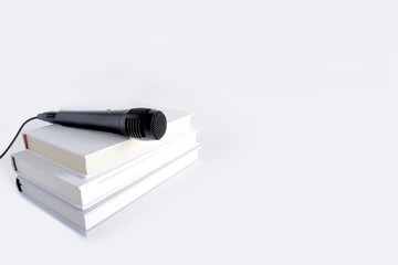 Isolated blur white background of books and a microphone on the top.