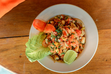 Ceviche closeup on a wooden table, top view.