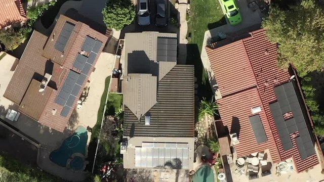 Solar panels installed on roofs of homes in suburb, aerial