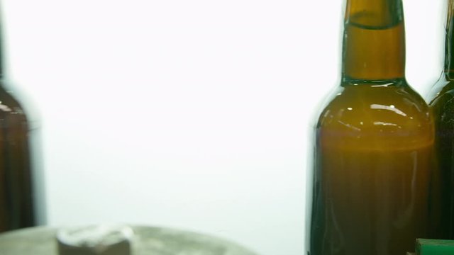 CU Filled bottles moving in front of inspection light in bottling plant