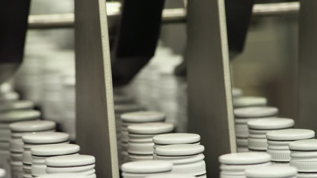 CU Bottles with caps moving into packaging machine in bottling plant