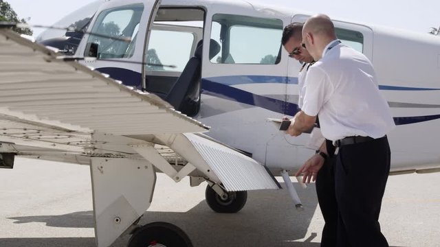 MS Flight instructor and trainee pilot during pre-flight inspection of aircraft