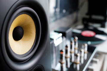 close up audio speaker with tube amplifier and turntable blur background