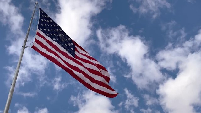 American Flag Waving on Wind With Clouds and Sky in Background, Close Up
