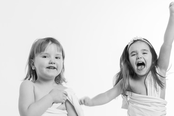 two little girls dancing on a white background. Children have fun. the concept of celebration, fun, recreation, childhood, friendship. Copy space