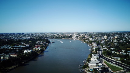 Obraz premium A photo of the Brisbane river with the suburb of East Brisbane on the right and the suburb of New Farm on the left. With a CityCat coming down the middle of the river.
