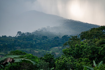 Rain squalls drench a mountain side in the jungles of  tropical West Africa in Ghana.