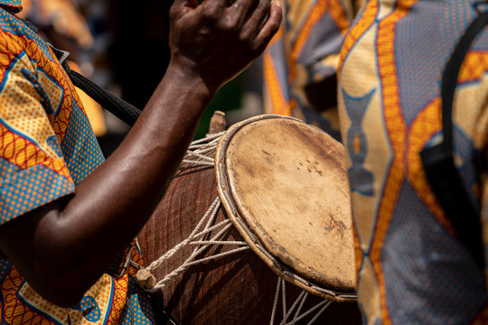 A closeup photo shows a drum and a drummers hands at the yam festival in Ghana, West Africa.