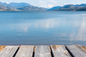 Aged gray picnic table-top with view of lake and mountains