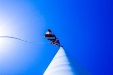 American flag flying high in a blue sky