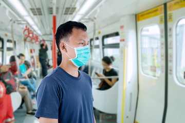 Unidentified man standing in the train with mask