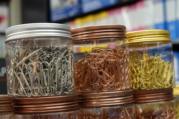 Picture of gold color and copper color and silver color paperclips in the bottle