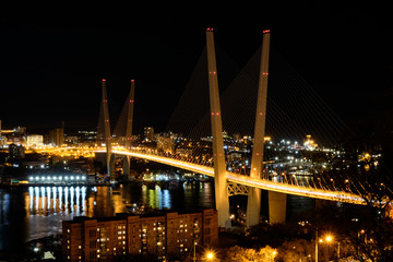 Fototapeta na wymiar Panorama of night Vladivostok. The bridge through a bay Golden Horn. Urban traffic with cityscape