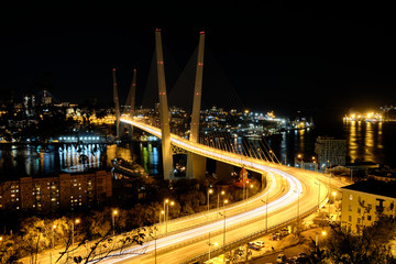 Fototapeta na wymiar Panorama of night Vladivostok. The bridge through a bay Golden Horn. Urban traffic with cityscape