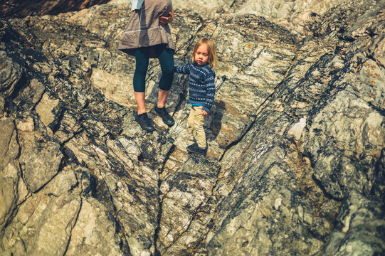 Pregnant woman and her preschooler walking on rocks