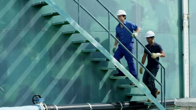 WS TS Two workers ascending stairs on storage tank