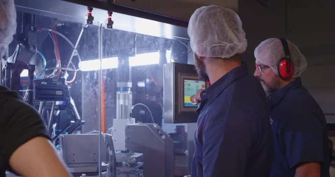 Machinery workers talking in factory