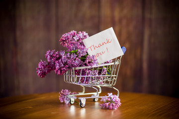 bouquet of spring blossoming lilacs in a shopping cart