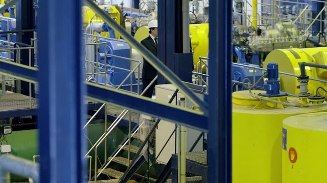 WS TS Two businessmen walking and talking on gangway in water treatment plant