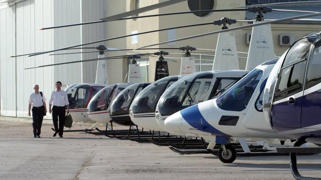 WS Two pilots walking along helicopter flight line and board business helicopter