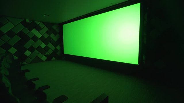 Modern cinema, view of the big green screen in the cinema hall, chromakey template in empty cinema hall.